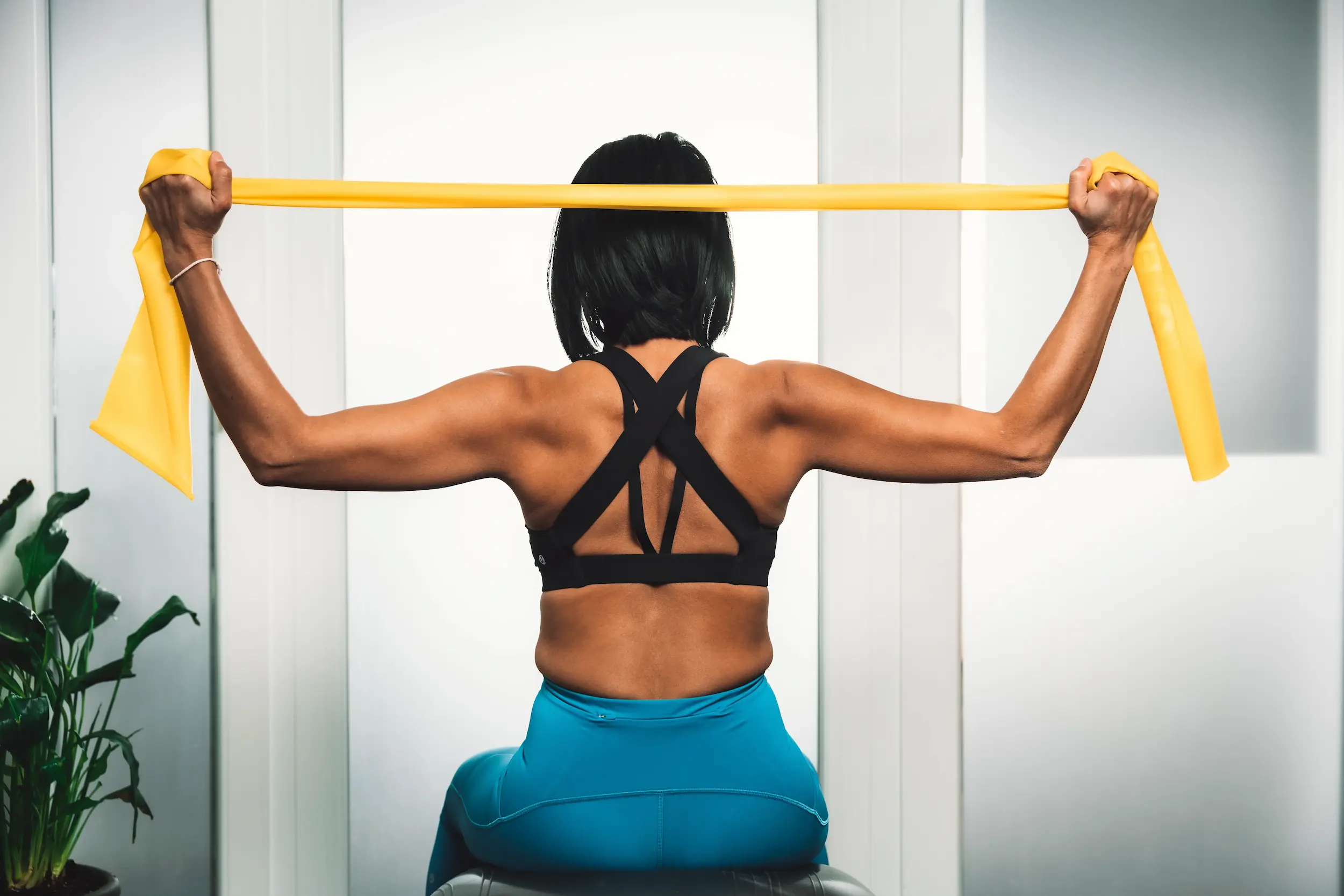 Pilates-Übung für den oberen Rücken: Gezieltes Schulterblatt-Training mit einem gelben Widerstandsband.